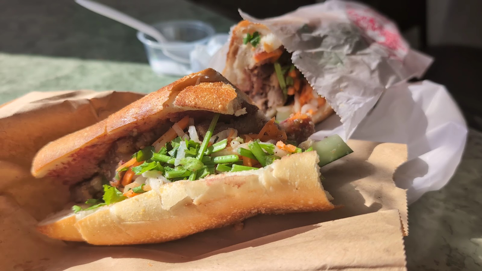 A freshly made banh mi with crisp bread, pickled carrot and cilantro at Ba Xuyên