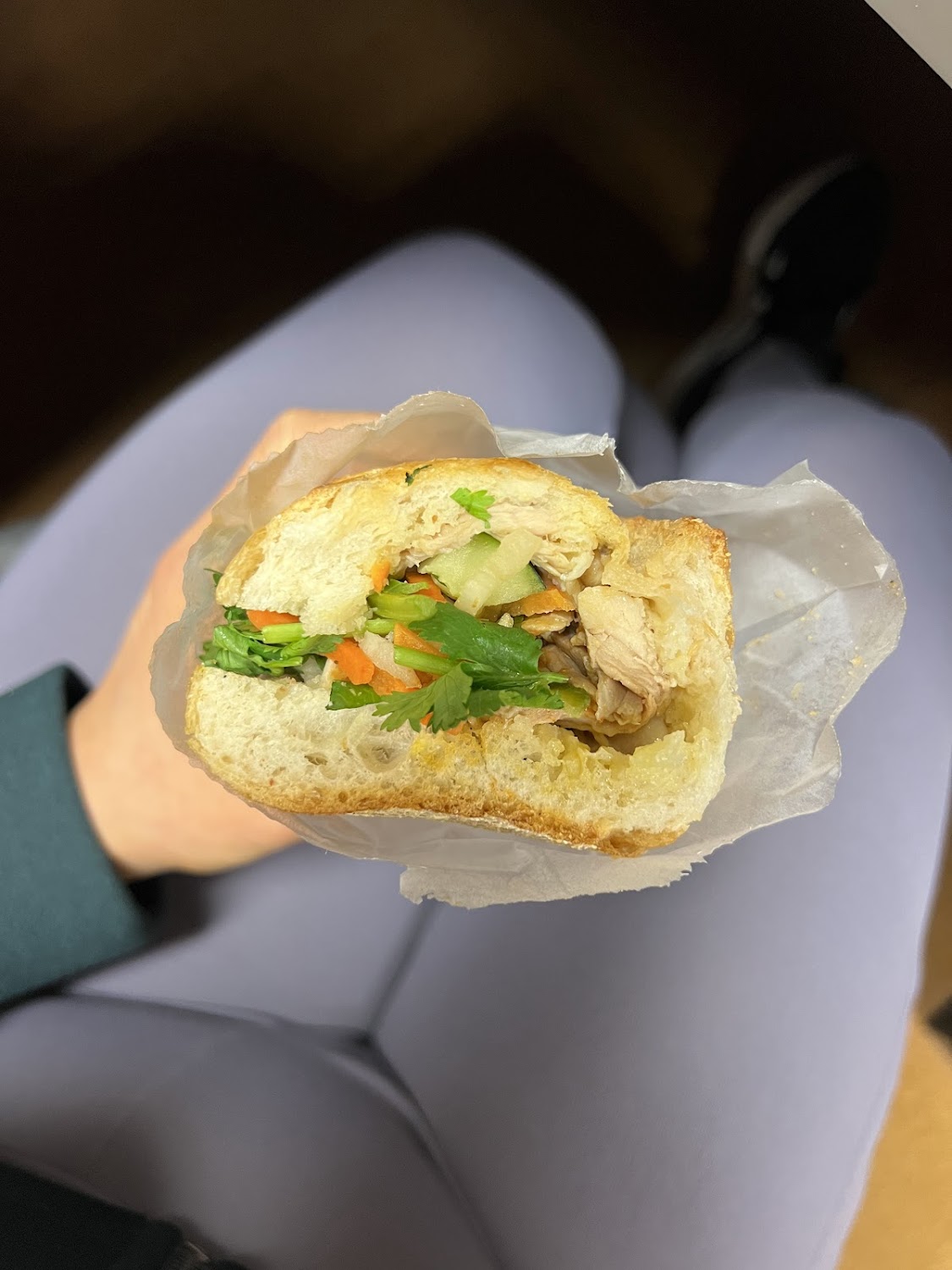 A banh mi held in hand, fresh from the counter